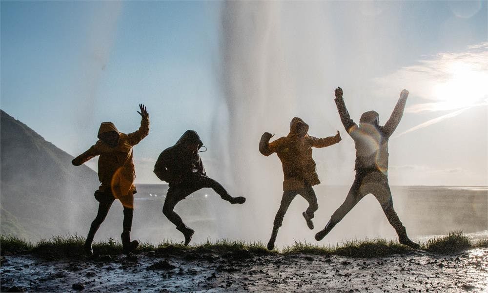 Travelers having fun behind Seljalandsfoss waterfall