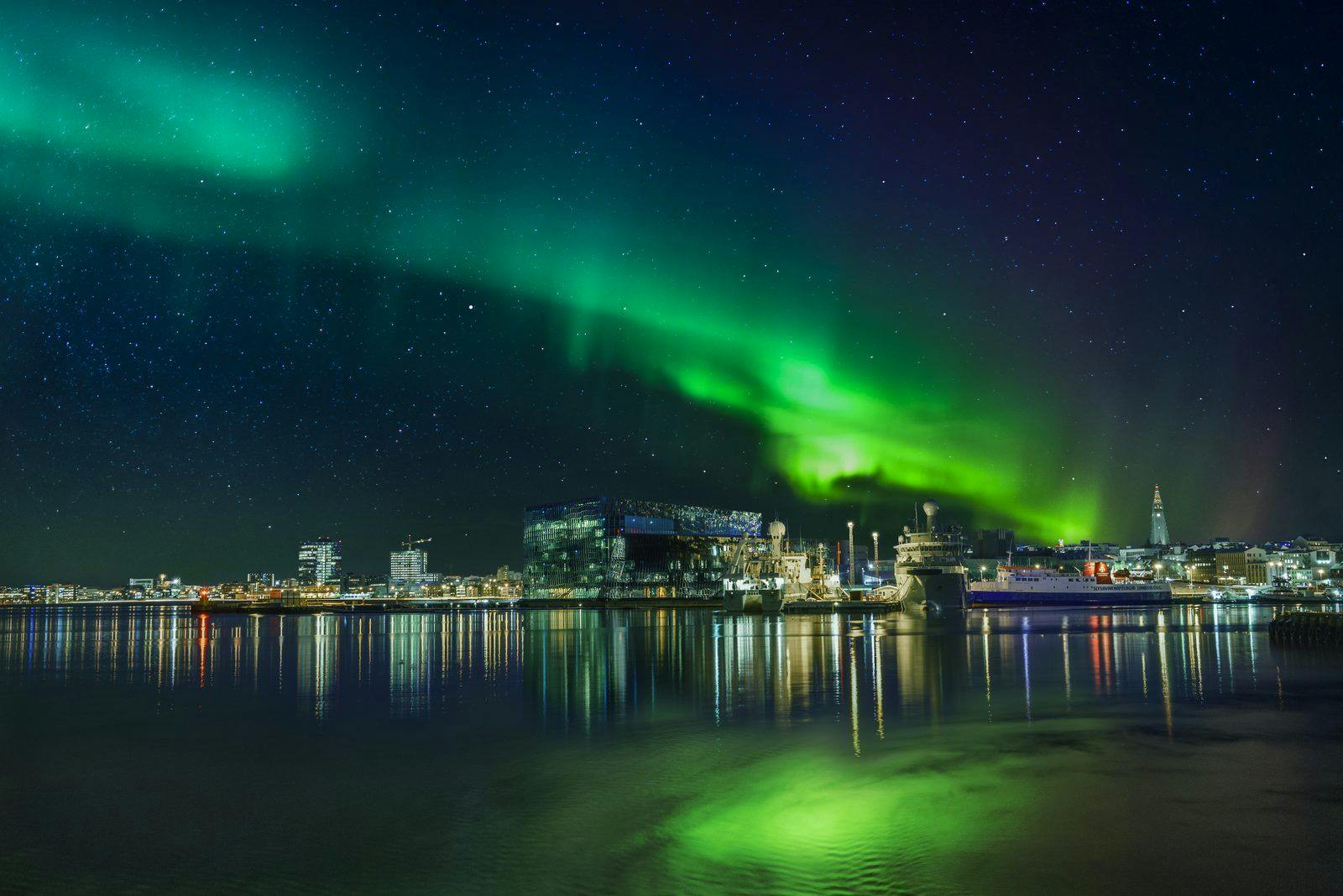 Aurora borealis over Hapra concert music hall in downtown Reykjavik